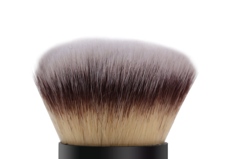 Makeup brush with black and brown bristles on a white background