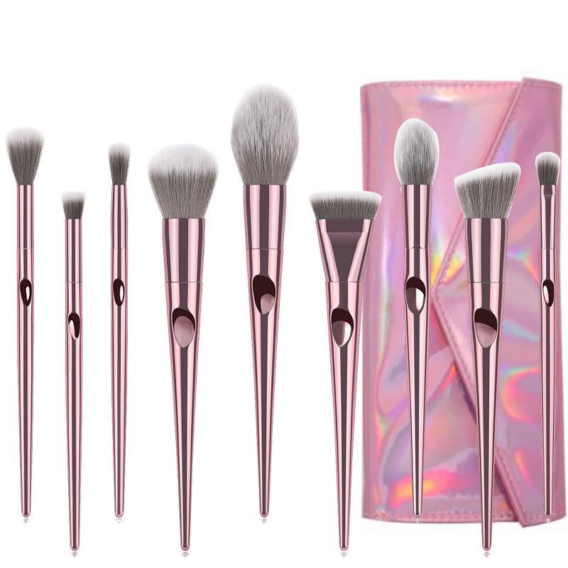 Set of makeup brushes with a pink and silver handle and gray bristles, accompanied by a pink and purple iridescent case.