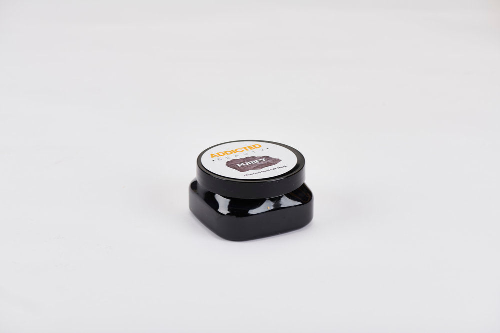Small black container with a white lid on a light gray background