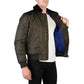 Person wearing a dark brown bomber jacket with blue lining on a white background