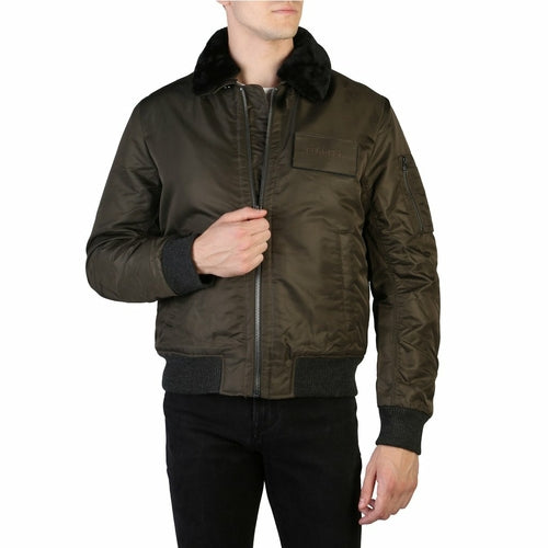 Man wearing a dark green bomber jacket with fur collar on a white background