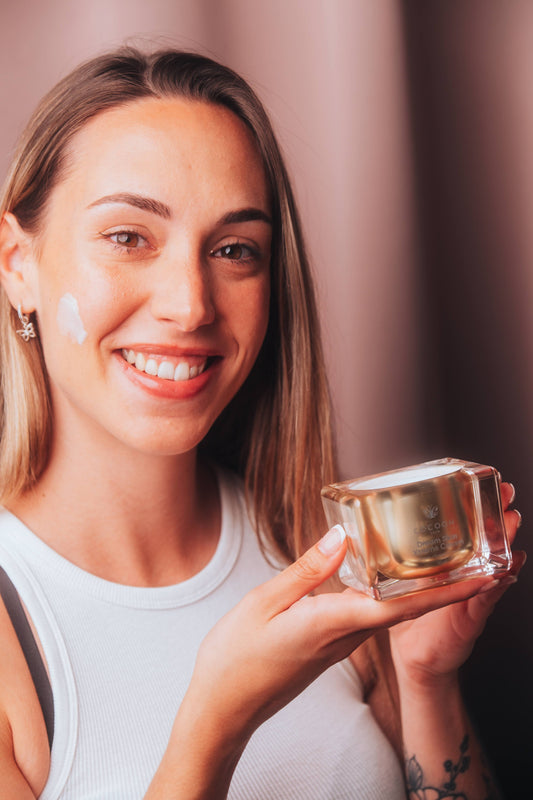 Woman holding a skincare product with a blurred background
