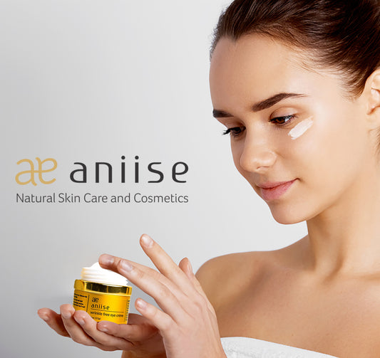Woman applying cream to her face with aniise skincare product in the foreground