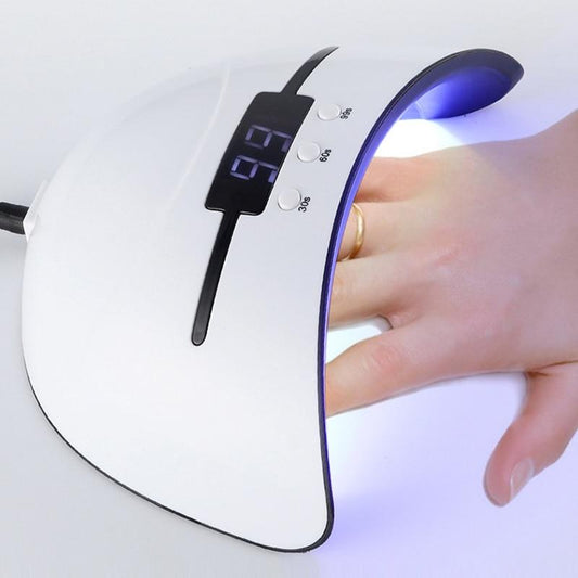 Nail dryer with a hand under it on a white background